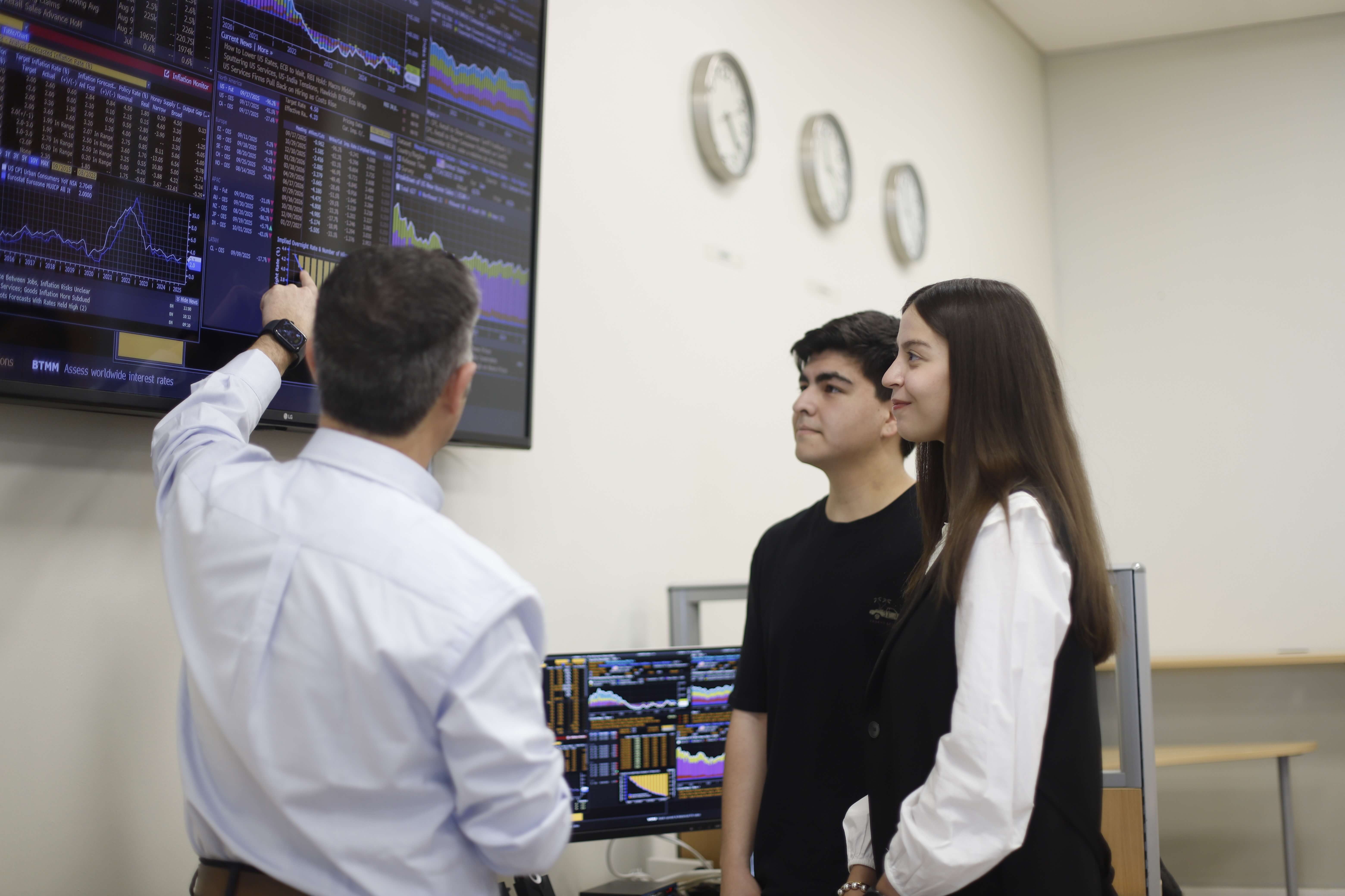 Profesor explicando indicadores económicos a estudiantes en el Laboratorio Bloomberg